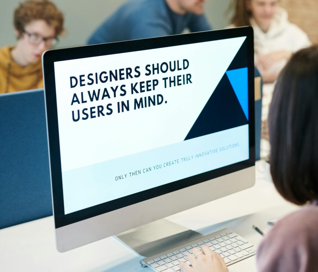 Group of designers collaborating in modern office space with computer.