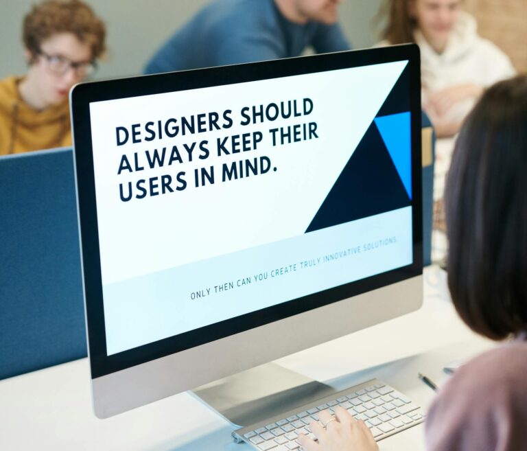 Group of designers collaborating in modern office space with computer.